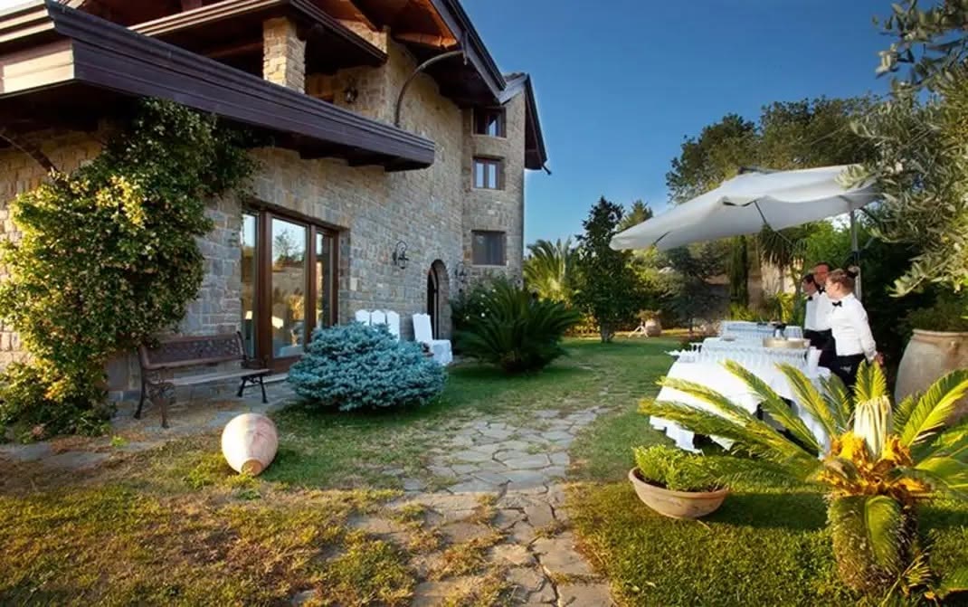 Il casale in pietra della tenuta visto dal giardino