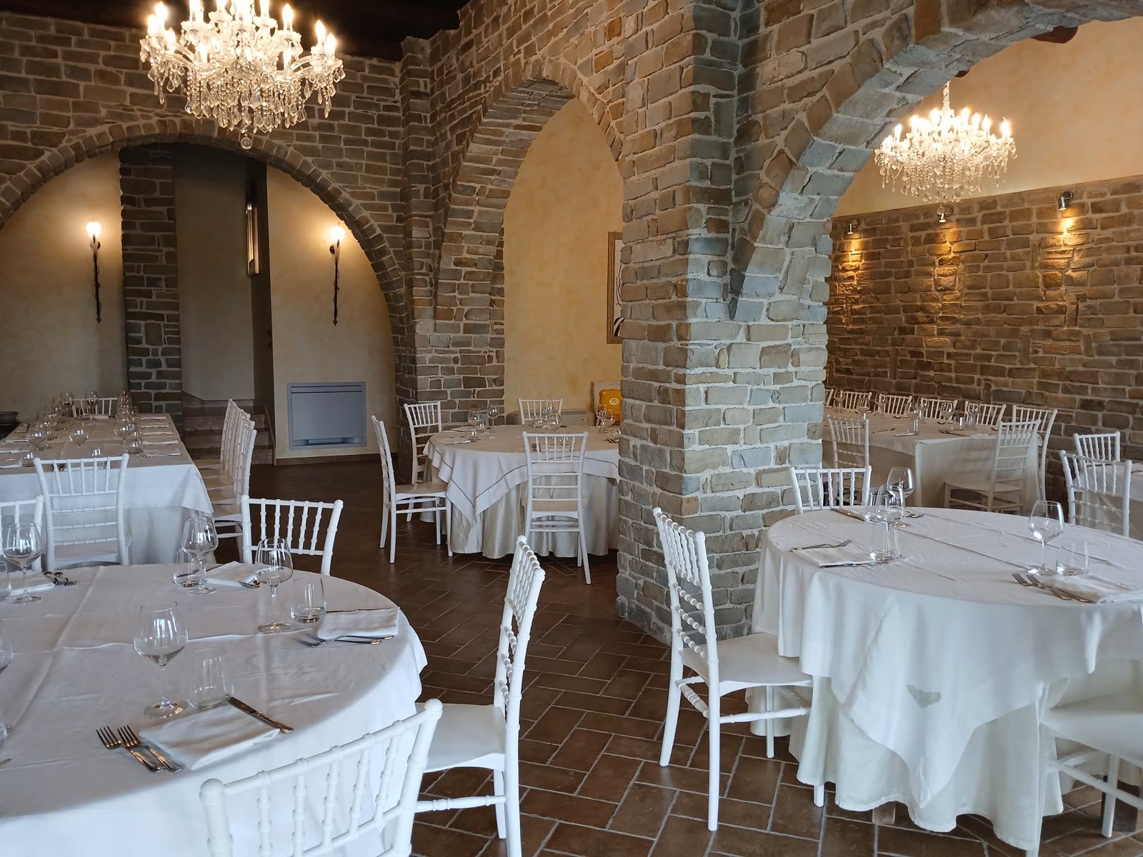 Il salone con gli archi in pietra e i lampadari di cristallo